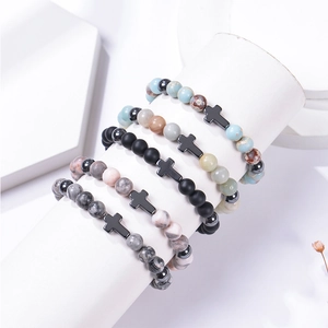 Close-up of 8mm pink zebra stone beaded bracelets set with metal cross charms