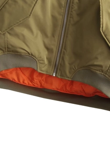 Detail of army green bomber jacket featuring orange lining and knit ribbed hem