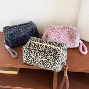 Three plush leopard print makeup bags in grey, pink, and brown with woven rope handles