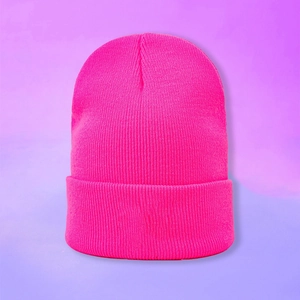 Gros plan du bonnet en tricot rose néon montrant la texture côtelée et le design à revers