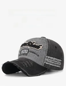 Détail de la broderie vieillie et des bords déchirés sur une casquette vintage délavée
