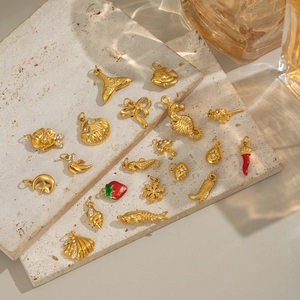 Detailed macro view of 18K gold-plated sea life and celestial charms on a stone surface