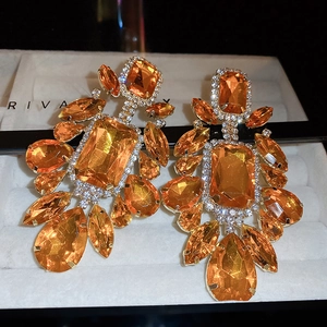 Detailed view of vintage palace style drop earrings with amber stones and crystals