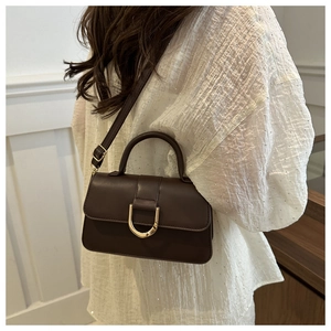 Detail of a dark brown PU leather handbag featuring a prominent gold D-shaped buckle