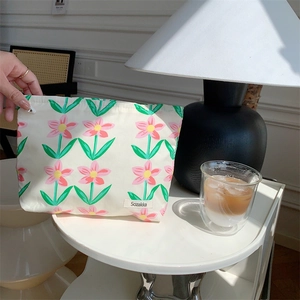 Detailed close-up of floral cotton pouch texture with Sozakka brand label on white desk