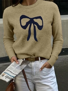 Women's khaki knit sweater with large blue bow pattern in a casual street style look