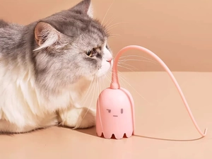 Pink ghost-shaped electric teaser wand showing a cat playing with the smart rotating toy