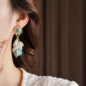 Detail of vintage bohemian drop earrings with turquoise beads and tassel fringe charms