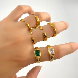 Détail de bagues empilables vintage dorées avec zircon émeraude et pierres baguettes