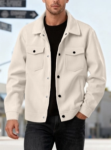 Detailed texture of off-white corduroy shirt jacket with black buttons and flap pockets