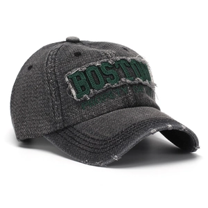 Détail d'une casquette vintage grise délavée avec broderie Boston verte et bords effilochés