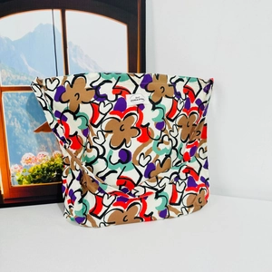 Macro detail of floral canvas tote bag featuring beige fabric with colorful flower patterns