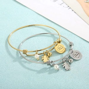 Détail de bracelets de Noël dorés et argentés avec perles et étiquette Joyeux Noël