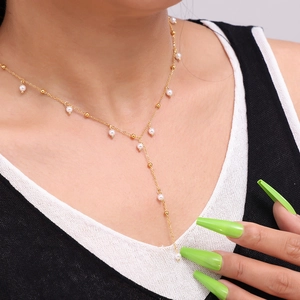 Elegant 18k gold plated titanium Y-shaped necklace with white pearls and gold beads on a model