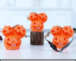 Three orange pumpkin lanterns shaped like Mickey Mouse heads with rustic rope handles