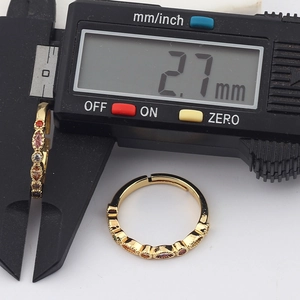 Calibrador digital midiendo el ancho de 2,7 mm de un anillo dorado con circonitas