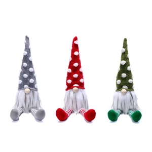 Close-up of three festive Christmas gnomes with polka dot hats and long striped legs