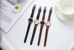 Flat lay of minimalist quartz watches with slim leather straps in black and brown colors