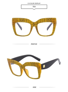 Dettaglio degli occhiali cat-eye quadrati con montatura ambra e stanghette nere