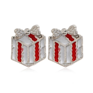 Gros plan de boucles d'oreilles boîte cadeau de Noël argentée avec nœud rouge et fini brillant