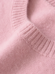 Close-up of pink knit sweater showing the ribbed neckline and soft fuzzy texture