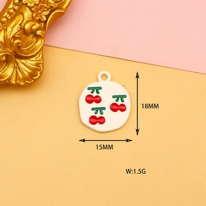 Detailed macro view of 18mm round enamel cherry pendant with red fruit and green leaves