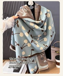 Detail of soft blue and brown scarf with white cherry patterns and fringe edges
