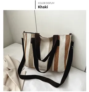 Detail view of khaki striped canvas tote bag with adjustable shoulder strap and handles