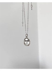 Close-up of a 925 sterling silver oval pendant with Smile text and a happy face icon