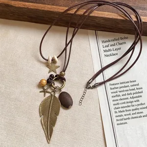 Close-up of vintage bronze feather and star pendant on brown cord with wooden beads