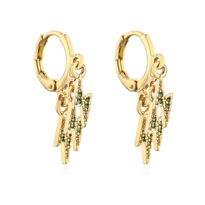 Close-up of gold lightning bolt earrings featuring vibrant green pavé cubic zirconia