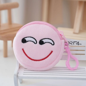 Close-up of pink plush coin purse with embroidered smiley face on mini wooden chair