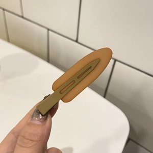 Detail of candy color matte hair clip featuring earthy yellow and light brown color blocks