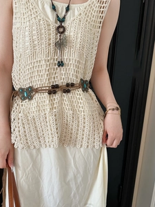 Detail of crochet hollow vest with ethnic style belt featuring butterfly decorations