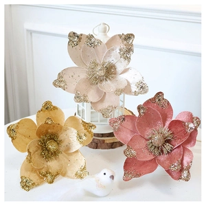 Detailed view of champagne and pink velvet Christmas flowers with gold glitter edges