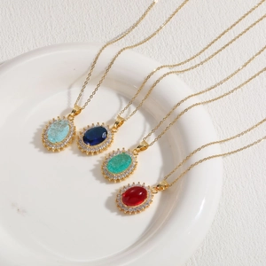 Detail view of four 14K gold plated necklaces with blue, green and red resin zircon charms