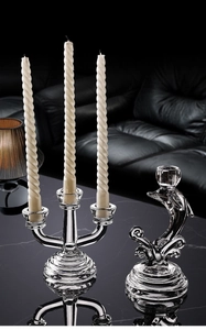 Detailed shot of transparent glass 3-arm candle holder with white spiral candles