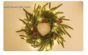 Detail of small Christmas wreath with artificial pine needles, cones and warm LED lights
