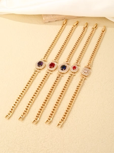 Macro shot of gold cuban link bracelets with colorful cubic zirconia stone centers