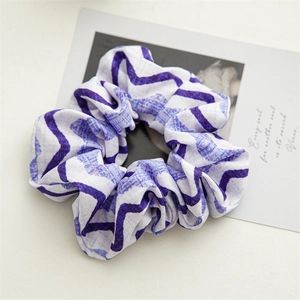 Detail of blue and purple wavy pattern on a soft fabric elastic scrunchie hair tie