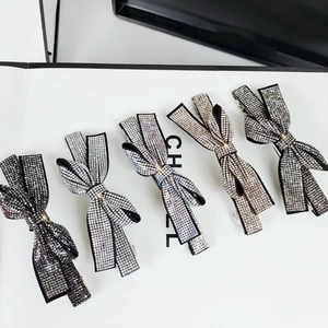Close-up of five crystal rhinestone bow hair clips in assorted sparkling colors
