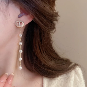Detail of luxury long tassel earrings with sparkling crystals and elegant white pearls