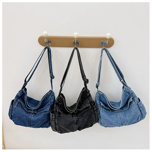 Three denim crossbody bags in dark blue, black, and light blue shown hanging side by side