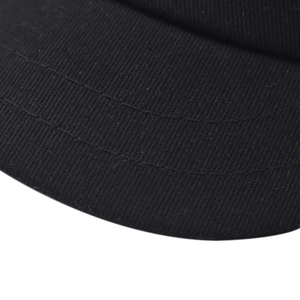 Détail macro de la double couture parallèle sur la visière courte noire du chapeau