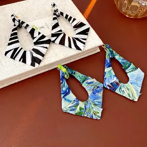 Geometric irregular fabric-wrapped hoop earrings in zebra print and floral patterns