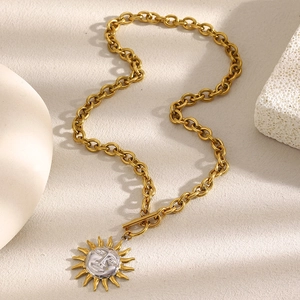 Close-up of gold stainless steel sun pendant necklace with silver face detail