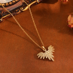 Close-up of golden eagle pendant with white zircon inlays on a vintage brown background