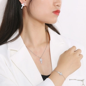 Set gioielli croce in acciaio argento con intarsio in conchiglia su modella in bianco