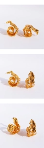Detailed views of gold feather earrings featuring intricate white zircon stone settings