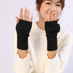 Detailed knit texture of black fingerless gloves with bow accent on a female wrist